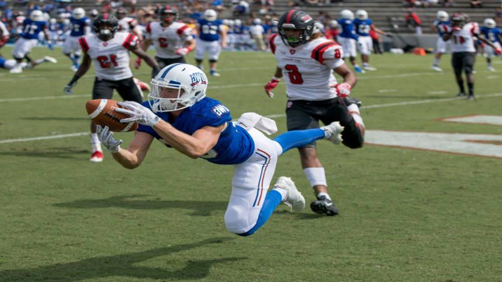 在线博彩 Football player catching a football during a game